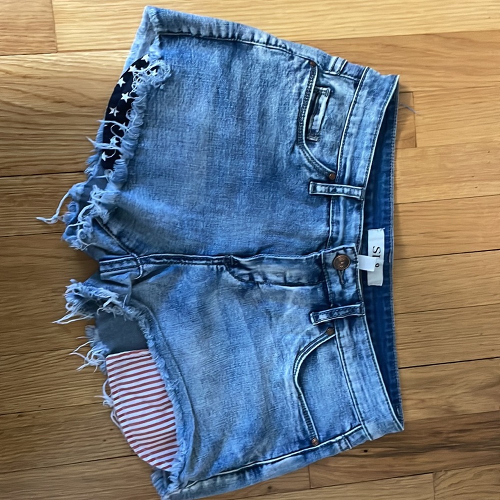 Size 27 light wash denim shorts with American flag pocket detail